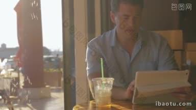 年轻人在白色的平板电脑里寻找东西，喝着冰茶，从透明塑料玻璃的小管在咖啡馆里